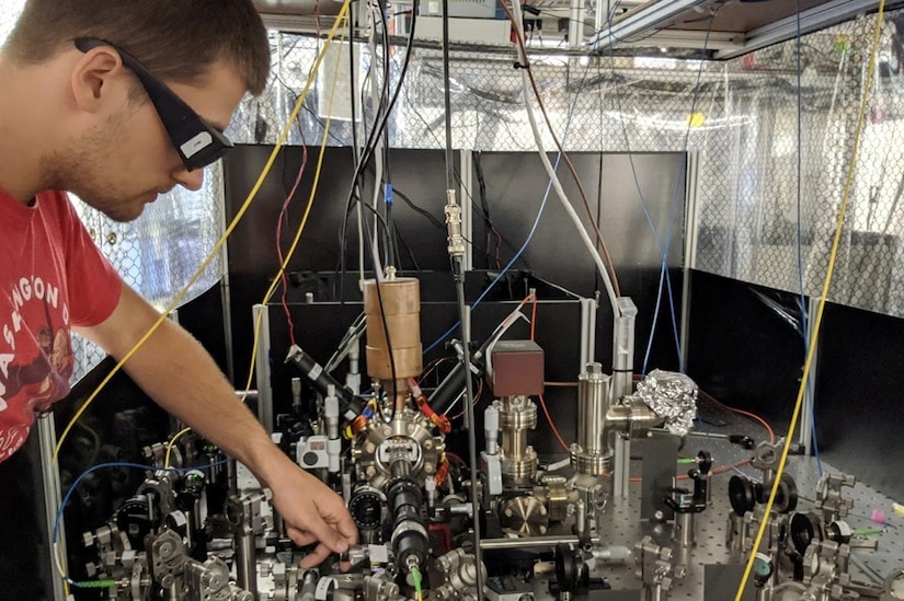 A scientist works with equipment attached to wires.