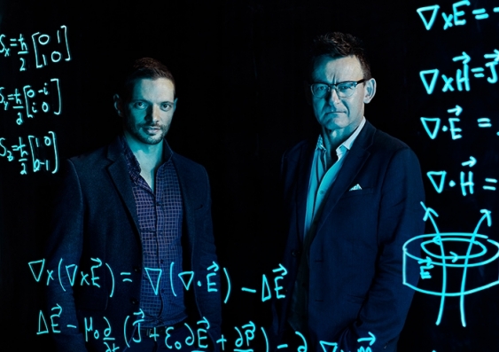 Dr Jarryd Pla and Prof. Andrew Dzurak look from behind a transparent screen showing mathematical workings Dr Jarryd Pla and Prof. Andrew Dzurak look from behind a transparent screen showing mathematical workings