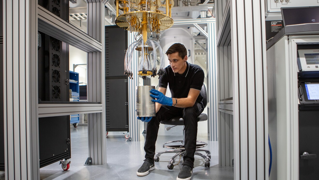 Photo of an AWS quantum hardware engineer working on a dilution refrigerator. 